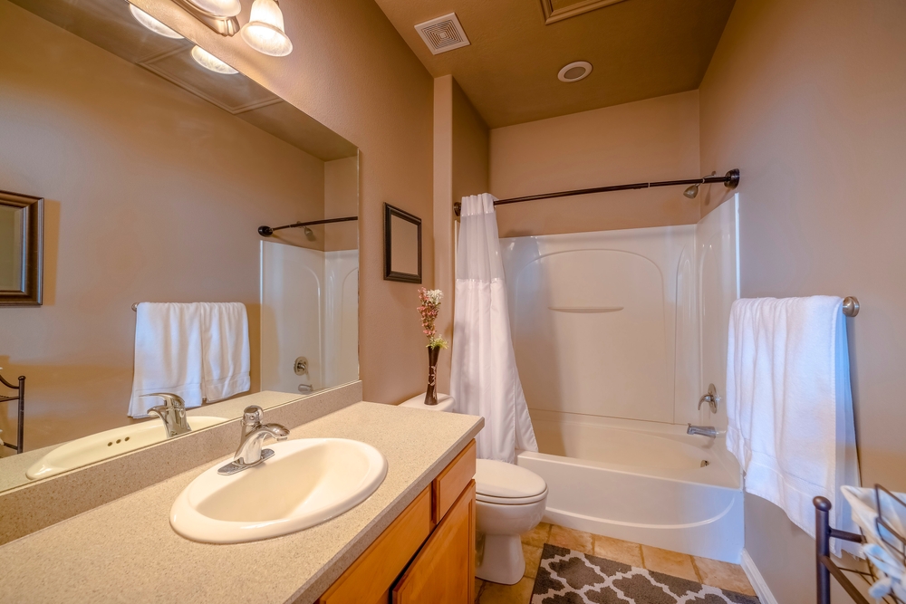 Windowless,Bathroom,With,High,Ceiling,And,Brown,Interior.,There,Is